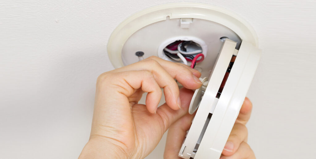 Person wiring their new smoke detector.